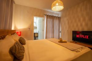 a bedroom with a white bed and a tv at ELOMY VILLA in Albion