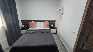 a bedroom with a large bed with pink pillows at Casa NOU in Cullera