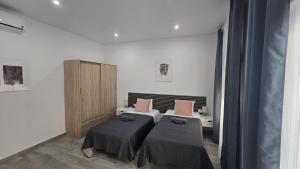 a room with two beds and a cabinet in it at Casa NOU in Cullera