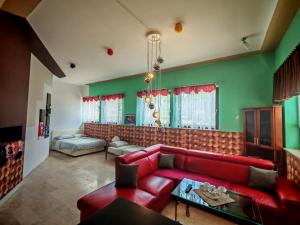 a living room with a red couch and green walls at WoW sleeping in Miklavž na Dravskem Polju