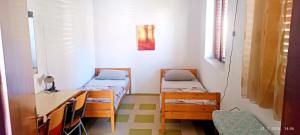a small room with two beds and a desk at Bonita in Mostar