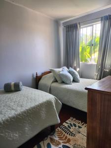 a bedroom with two beds and a window at Casa Runa in Quillota