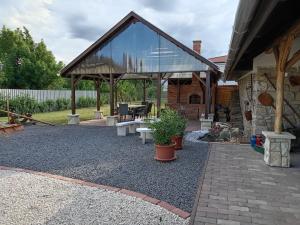 a patio with a glass roof with benches and tables at Cinege Vendégház in Tolcsva