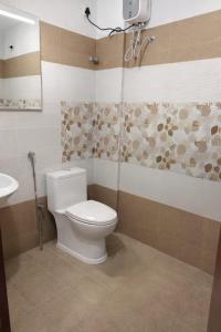a bathroom with a toilet and a sink at Palazhi Stay 160m from Guruvayur Temple in Guruvāyūr