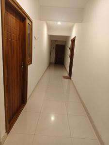 an empty hallway with a door and a tile floor at Palazhi Stay 160m from Guruvayur Temple in Guruvāyūr +1 photo