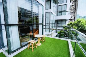 a balcony with green grass and a table and chairs at Dhaka Unique Regency in Dhaka