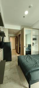 a bedroom with a bed and a large mirror at Smart Studio - BResidences ICE BSD in Tjilandak