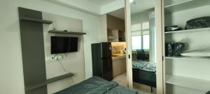 a bedroom with a mirror and a bed and a television at Smart Studio - BResidences ICE BSD in Tjilandak
