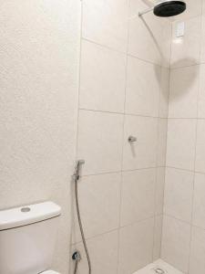 a white bathroom with a shower with a toilet at Confort Quixada in Quixadá
