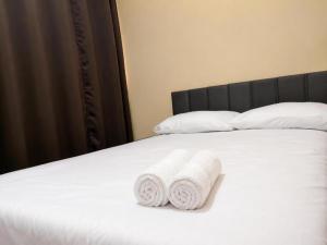 two rolled towels are sitting on a bed at Confort Quixada in Quixadá