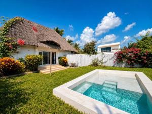 a house with a swimming pool in the yard at Raffia Boutique Hotel in Jambiani