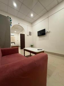 a living room with a red couch and a table at Heritage Home in Guwahati