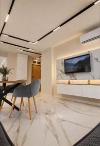 a living room with a table and a television on a wall at Nikol River Residence in Sandanski +8 photos