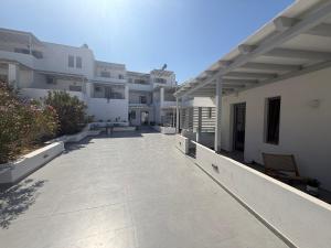 a large courtyard of a building with white buildings at CAELI PAROS by Kostas & Joanna Studios in Logaras
