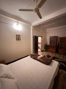 a bedroom with a bed and a ceiling fan at Heritage Home in Guwahati