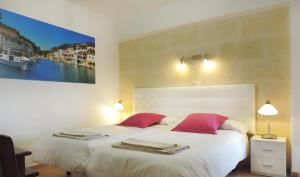 a bedroom with two beds with red pillows at Marblau Mallorca in Cala Figuera