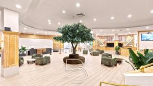 a large lobby with a tree in the middle at Girasole Apartments in Miami Beach