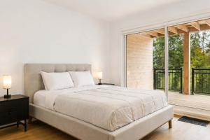 a bedroom with a large bed and a large window at Spa - River - Game Room - Le Belvedere in Mont-Tremblant