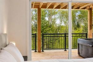 a bedroom with a view of a balcony with a tub at Spa - River - Game Room - Le Belvedere in Mont-Tremblant