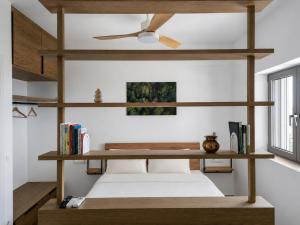 a bedroom with a bed with a ceiling fan at Trigono Suites - Karat in Politika