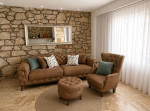 a living room with a couch and a stone wall at Villa "Lala" in Ljubuški