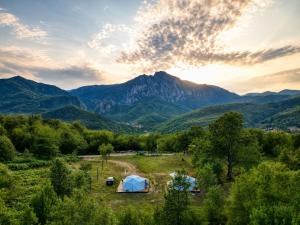 a tent in a field with mountains in the background at Sutjeska Glamping Domes in Tjentište