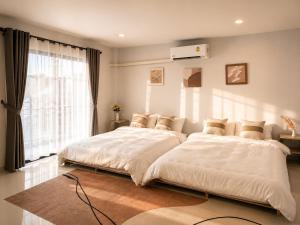 a bedroom with two beds and a window at Nasrina's House Hat Yai ใกล้เซ็นทรัลหาดใหญ่ in Sathani Khlong Rian