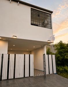 a white building with a window on top of it at Nasrina's House Hat Yai ใกล้เซ็นทรัลหาดใหญ่ in Sathani Khlong Rian