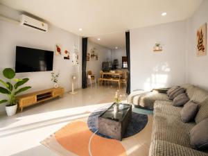 a living room with a couch and a tv at Nasrina's House Hat Yai ใกล้เซ็นทรัลหาดใหญ่ in Sathani Khlong Rian