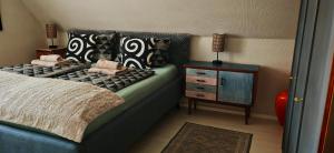 a bedroom with a bed with pillows and a night stand at Ferienhaus VILLA ZAUBERBLICK am Rennsteig Frankenwald FREISTEHEND naturnah HUNDEFREUNDLICH eingezäunt in Ludwigsstadt
