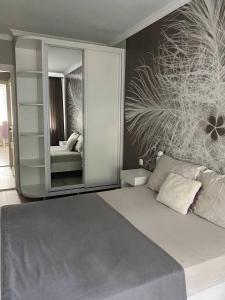 a bedroom with a bed with a large mirror at Spacious apartment with a beautiful view in Căuşeni