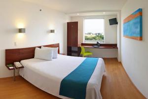 a hotel room with a large bed and a desk at One Xalapa Las Animas in Xalapa +28 photos