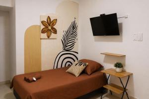a bedroom with a bed with a tv on the wall at Hotel Riviera Central in Montería