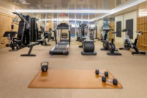 a gym with treadmills and cardio equipment on the floor at Hotel Residence Europe & Spa in Clichy