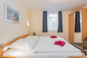a bedroom with two beds with red towels on them at Haus Roland, Wohnung 04 in Zinnowitz