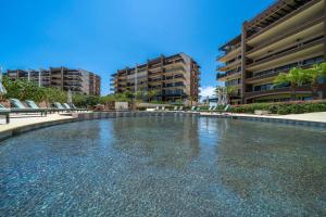 a swimming pool with chairs in front of some buildings at Luxury House with Ocean View in Cabo San Lucas