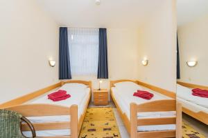 a bedroom with two beds and a window at Haus Roland, Wohnung 04 in Zinnowitz +5 photos
