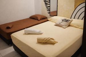 two beds sitting next to each other in a room at Hotel Riviera Central in Montería