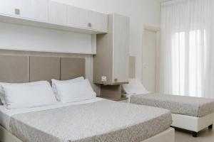 a hotel room with two beds and a window at Hotel Caravel in Vasto