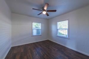 a living room with a ceiling fan and two windows at Park Street Apartment - Front Unit in Paso Robles +2 photos