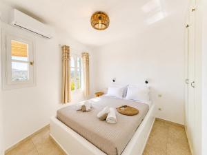 a white bedroom with a bed with towels on it at Uranos studios Amorgos in Amorgos