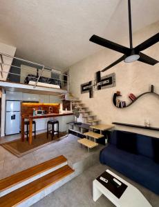 a living room with a blue couch and a kitchen at Caribbean apartment in Cancún