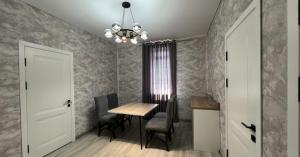 a dining room with a table and chairs and a chandelier at Van park hotel in Shymkent +18 photos