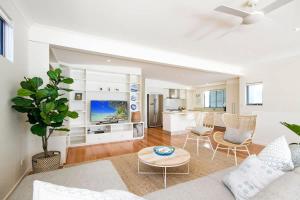 a living room with a couch and a table at Tranquil & Modern Riverside Getaway in Noosaville
