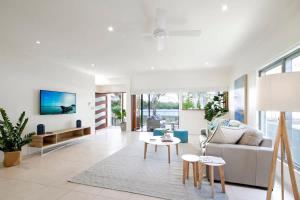 a living room with a couch and a table at Tranquil & Modern Riverside Getaway in Noosaville +9 photos