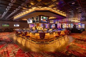 a bar in a casino with a bunch of slot machines at Prospector Hotel & Gambling Hall in Ely