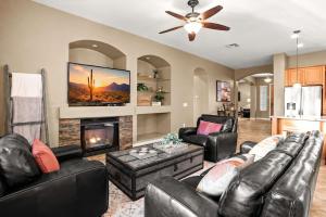a living room with leather furniture and a fireplace at Movie Theater Pool Arcade Fire Pit in Glendale