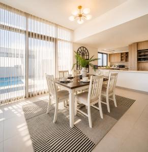 a kitchen and dining room with a table and chairs at Ajmal Villa in Al Ḩamrīyah