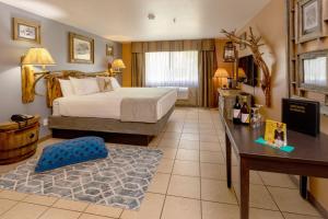 a hotel room with a bed and a table and a desk at Prospector Hotel & Gambling Hall in Ely +18 photos