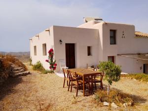 a wooden table and chairs in front of a house at Kortijo Martzala in Lucainena de las Torres
